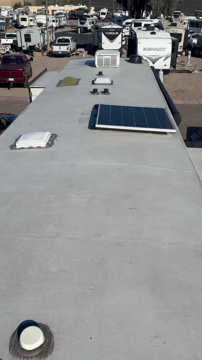 Inspector examining an RV roof as part of a used-RV inspection